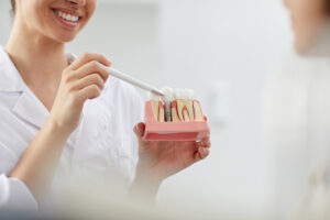 Dentista explicando ao paciente como é realizado o procedimento de implante dentário