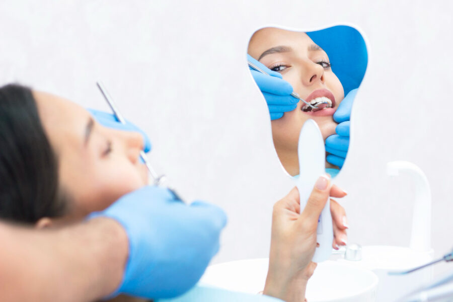 profilaxias dentárias: mulher fazendo limpeza dentária
